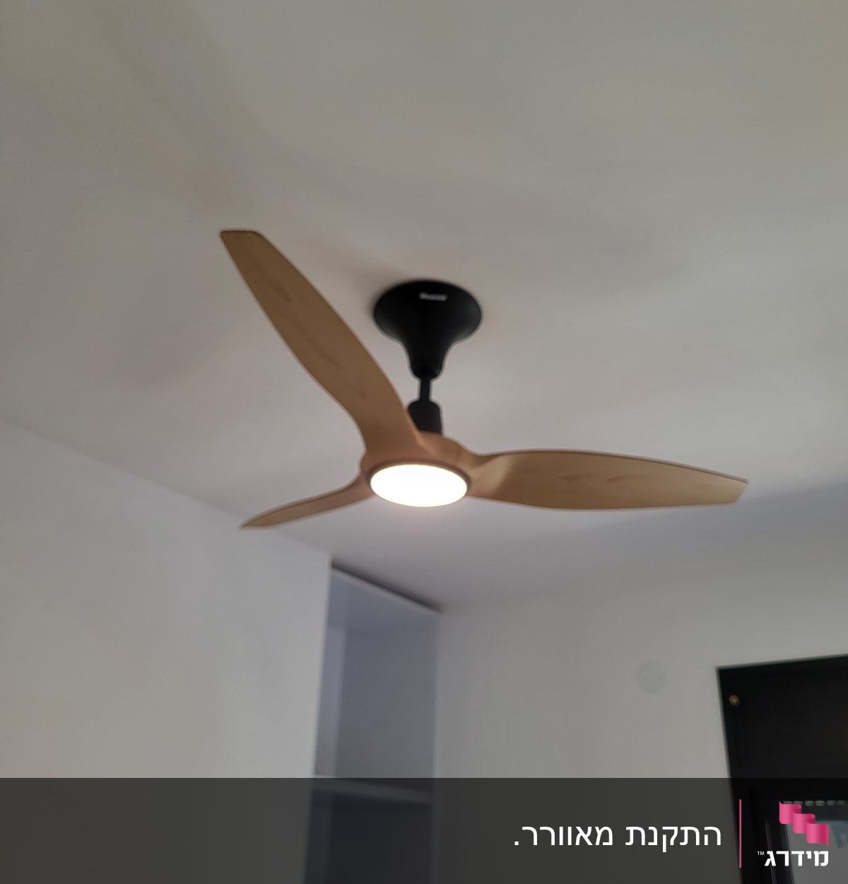 מאוורר תקרה עם תאורה מותקן על תקרה לבנה